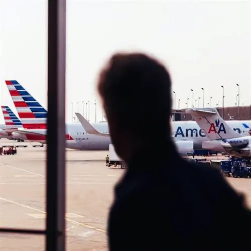 Силуэт человека, наблюдающего за парком самолетов American Airlines в международном аэропорту Чикаго О'Хара