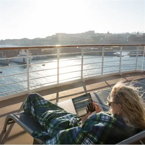 Женщина расслабляется с цифровым планшетом под одеялом, Digital Nomad