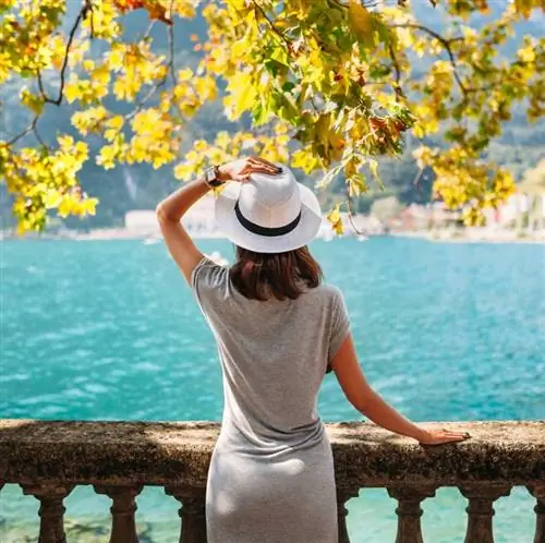 Женщина смотрит на воду с балкона