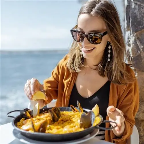 Женщина наслаждается паэльей