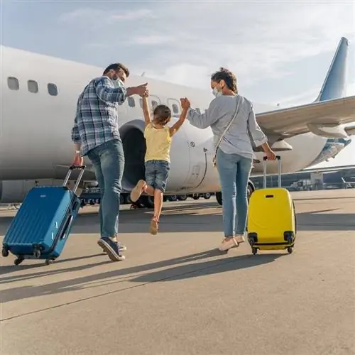 Вид сзади на счастливую семью, садящуюся в самолет перед международным путешествием