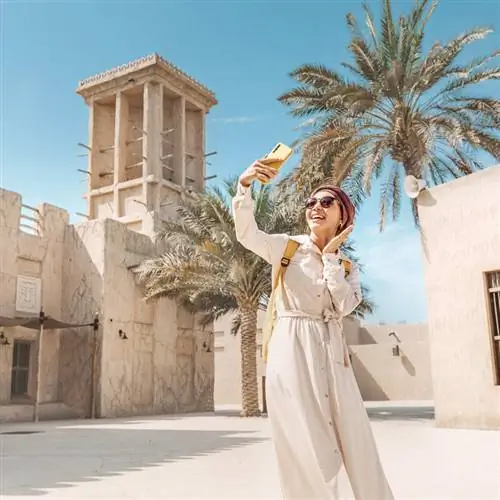 Счастливая женщина в тюрбане делает селфи в старом историческом центре Дубая, Объединенные Арабские Эмираты