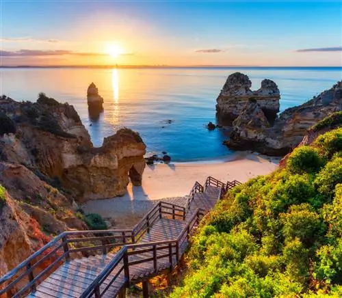 Пляж Камило (Прайя-ду-Камило) в Алгарве, Португалия, на фоне бирюзового моря. Деревянный пешеходный мост на пляж Прайя-ду-Камилу, Португалия. Прекрасный вид на пляж Камило в Лагосе, Алгарве, Португалия. (Пляж Камило (Прайя-ду-Камило) в Алгарве, Португа