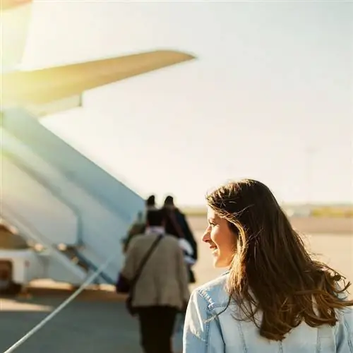 Улыбающаяся путешественница садится в самолет