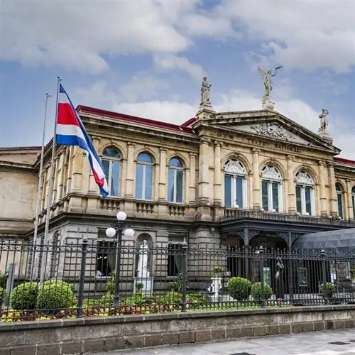 Национальный театр Коста-Рики в Сан-Хосе с развевающимся флагом Коста-Рики