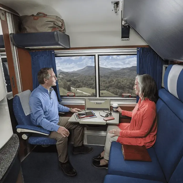 Пожилая пара наслаждается кофе из своей комнаты в спальном поезде Amtrak, концепция путешествия на поезде