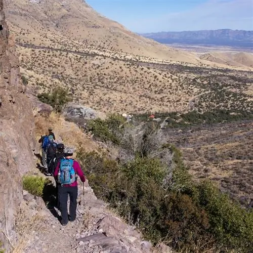 Группа туристов спускается по каменистой пешеходной тропе в Сьерра-Виста