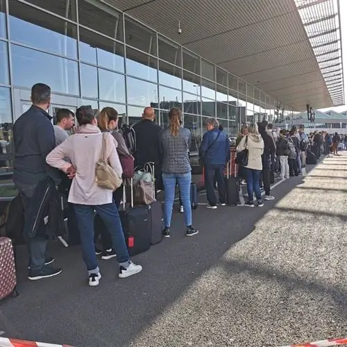Длинная очередь ожидания возле терминала аэропорта в аэропорту Амстердама Схипхол, Голландия, Нидерланды, Концепция хаоса международных путешествий