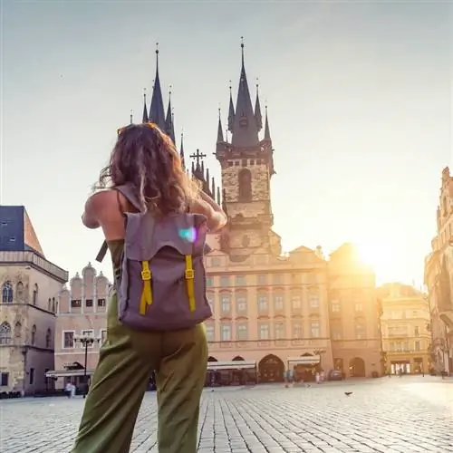Молодая женщина фотографируется из Тынской церкви в Праге