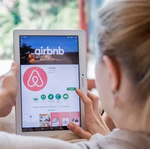Женщина устанавливает Airbnb на планшет