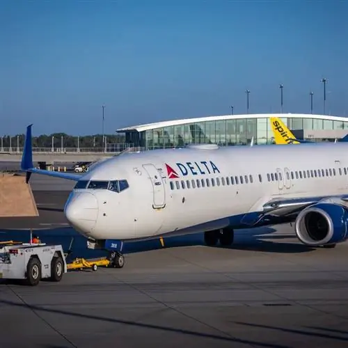 Самолет Delta припаркован на взлетно-посадочной полосе аэропорта