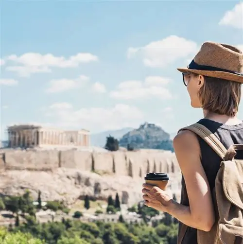 Молодая путешественница смотрит на Афины, Грецию, с Парфеноном на заднем плане
