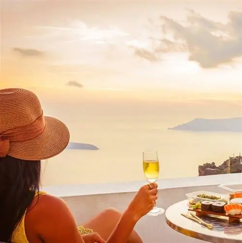 Женщина ест и пьет шампанское после поездки в Грецию