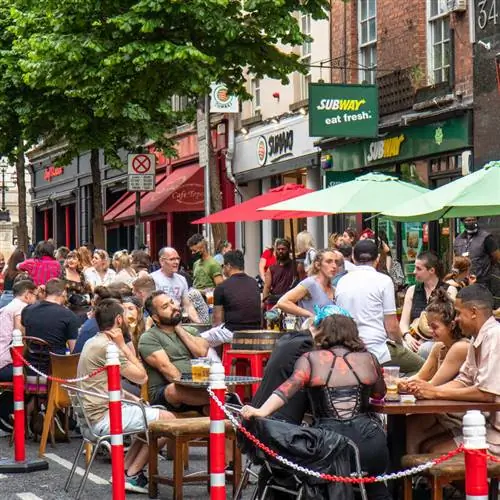 Люди наслаждаются напитком и едой в солнечный день в Дублине, Ирландия, переполненные улицы в постковидном мире