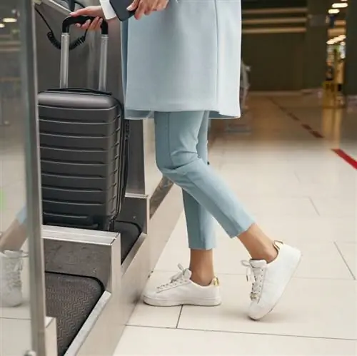 Женщина сдает багаж в аэропорту