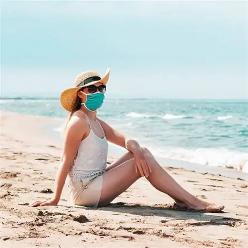 Молодая женщина в маске на пляже