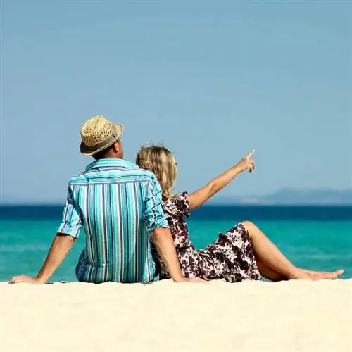 Пара наслаждается днем на пляже в райском месте, неизвестно