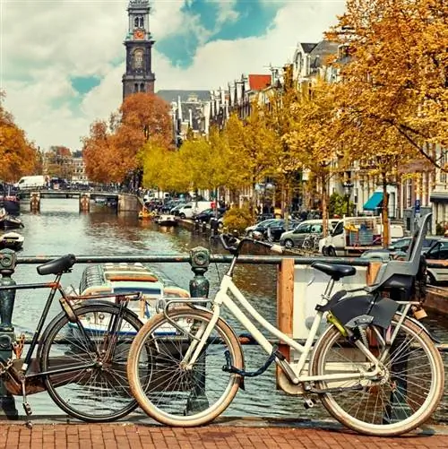 Канал Амстердама с велосипедами, запертыми на рельсах моста