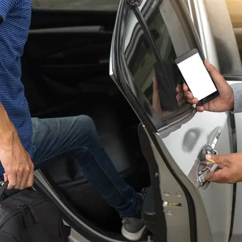 Одинокий путешественник-мужчина садится в такси или автомобиль Uber, когда водитель открывает ему дверь, концептуальное изображение Uber