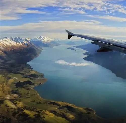 вид из окна с самолета Air New Zealand на море и заснеженные горы