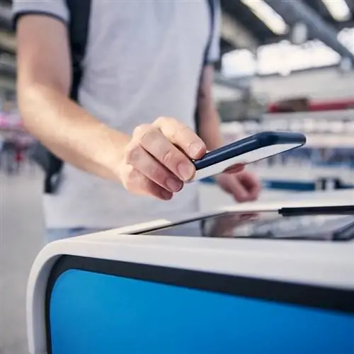 Путешественник сканирует посадочный талон в цифровом киоске в аэропорту