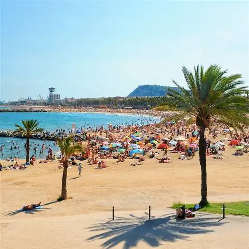 Туристы и вид на пляж Барселоны в летний день