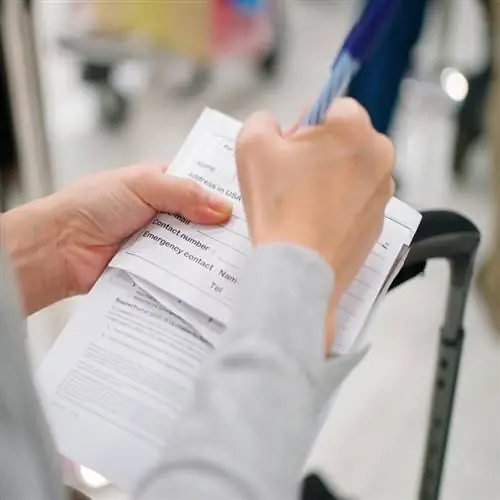 Авиапассажир заполняет форму прибытия или регистрации перед международным путешествием