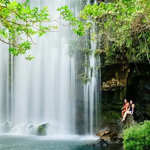Две женщины отдыхают рядом с водопадом. Водопад Льянос-де-Кортес в Багасесе, Гуанакасте