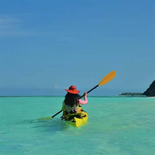 Девушка гребет на каяке, исследуя Теркс и Кайкос.