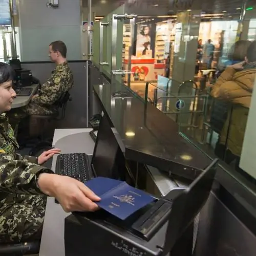 Пограничник сканирует то, что похоже на австралийский паспорт, во время пограничного контроля, международные поездки