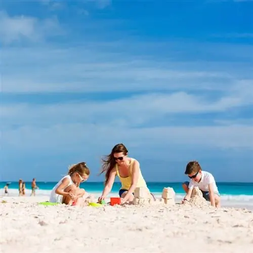 Мать и дети, семейное строительство замков из песка на тропическом пляже, местоположение не указано, Карибский бассейн