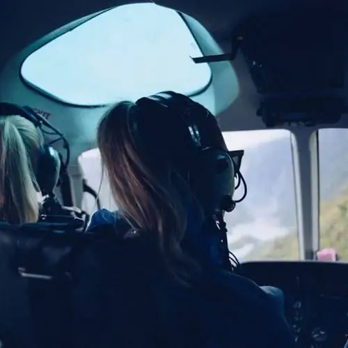 женщина в вертолете в наушниках