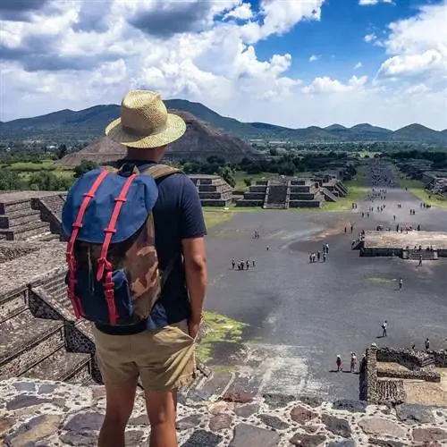 Молодой турист-мужчина наблюдает за историческими доколумбовыми пирамидами в Мексике, Латинская Америка