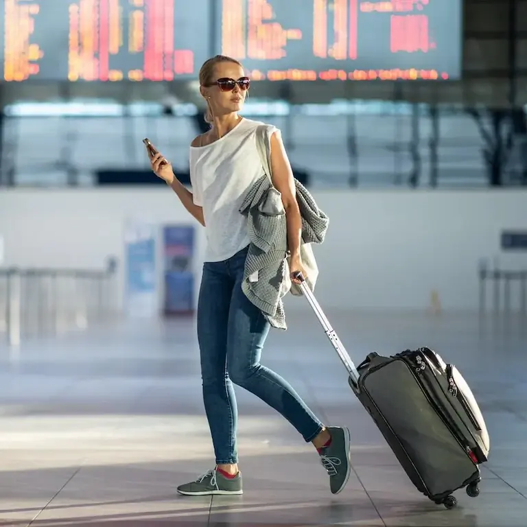 Женщина с багажом в аэропорту