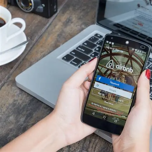 человек использует приложение airbnb на телефоне