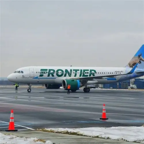 Самолет Frontier Airlines готовится к взлету с взлетно-посадочной полосы аэропорта