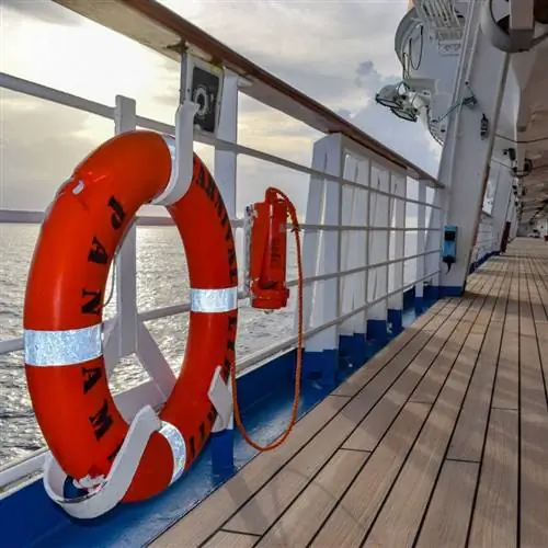 Оранжевый спасательный круг висит на перилах на палубе круизного лайнера Carnival Liberty.