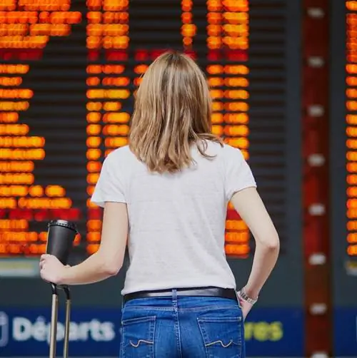 Женщина, стоящая перед табло вылета в аэропорту, отменила рейс