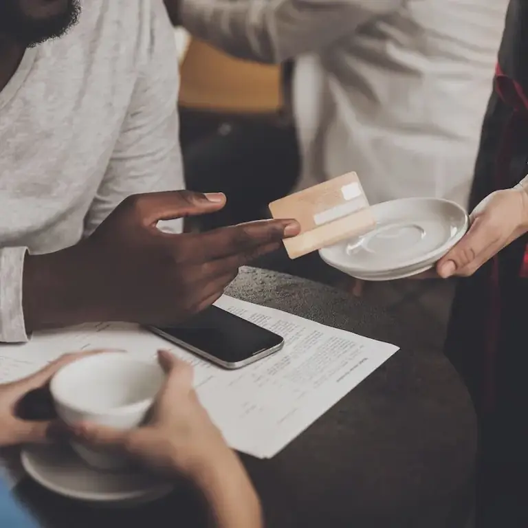 Мужчина дает карту для оплаты счета в ресторане