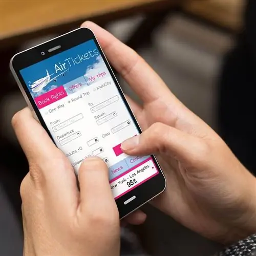 Женщина-путешественница бронирует авиабилеты на своем телефоне