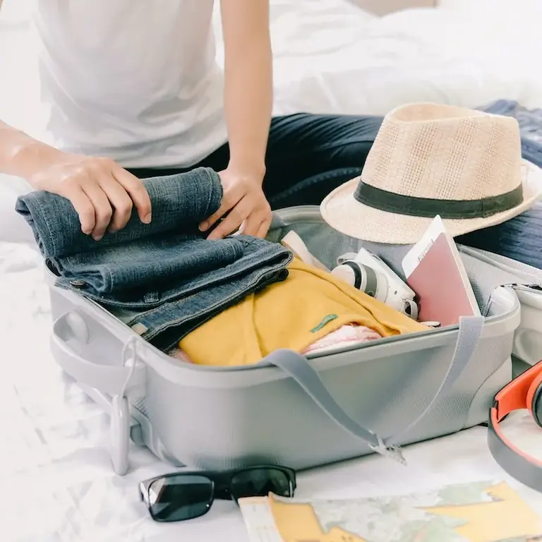 Женщина собирает чемодан перед поездкой