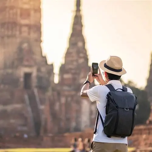 Турист фотографирует буддийский храм в Таиланде, Юго-Восточная Азия
