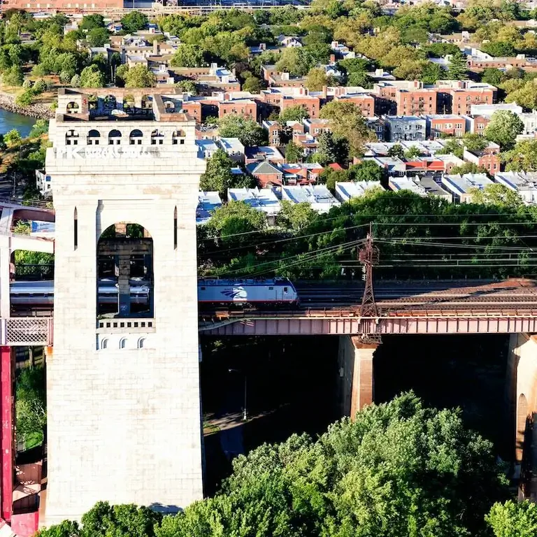 Вид с воздуха на поезд Amtrak, пересекающий мост Hell Gate в Нью-Йорке.