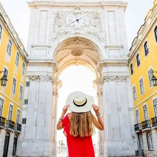 Женщина смотрит на городские ворота в Лиссабоне, Португалия