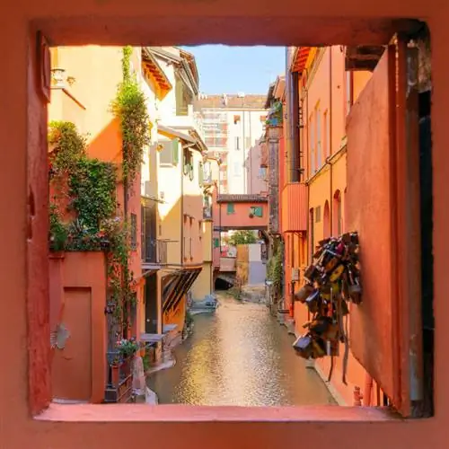 Маленькое секретное окно под названием Finestrella, выходящее на причудливый красочный канал в Болонье, Италия