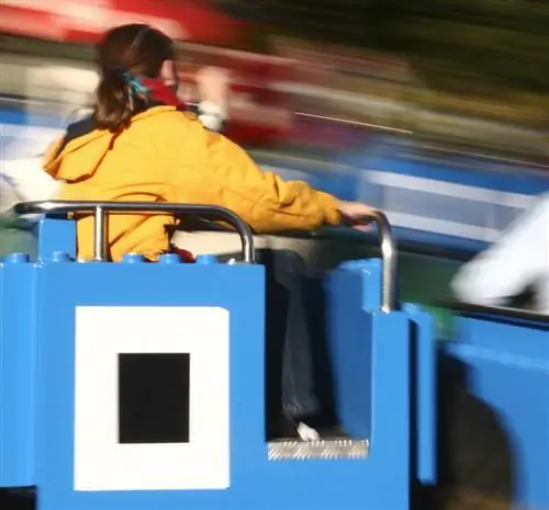 Женщина в желтой куртке в аттракционе в форме лего, Орландо