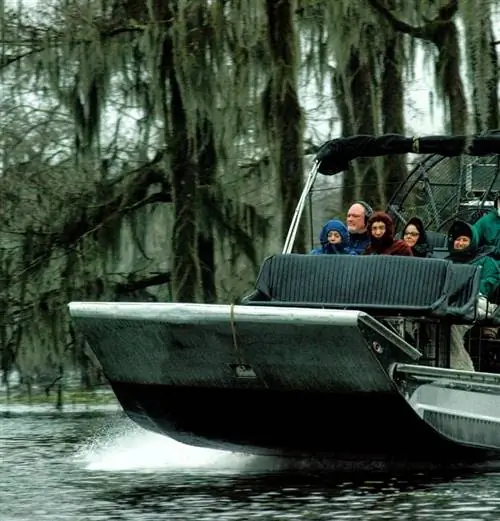 Группа людей во время прогулки на воздушном судне по болоту.