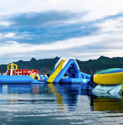 Красочная надувная полоса препятствий, плавающая по озеру.