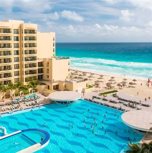 Вид с воздуха на курорт в Канкуне, Мексика, с бассейном и пляжем, и путешественники наслаждаются своим днем