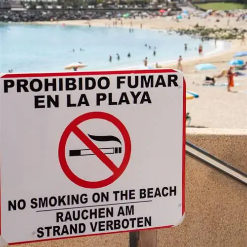 Знак запрета на курение на пляже, полном туристов в солнечный день